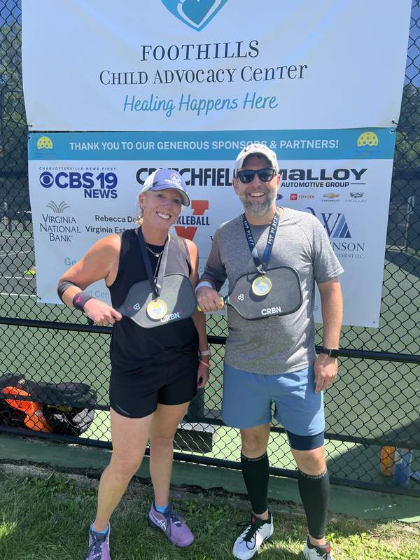 Amanda Sovik-Johnston and partner John Gaskins with first-place medals at the Foothills Child Advocacy Center pickleball tournament in Charlottesville, Virginia.