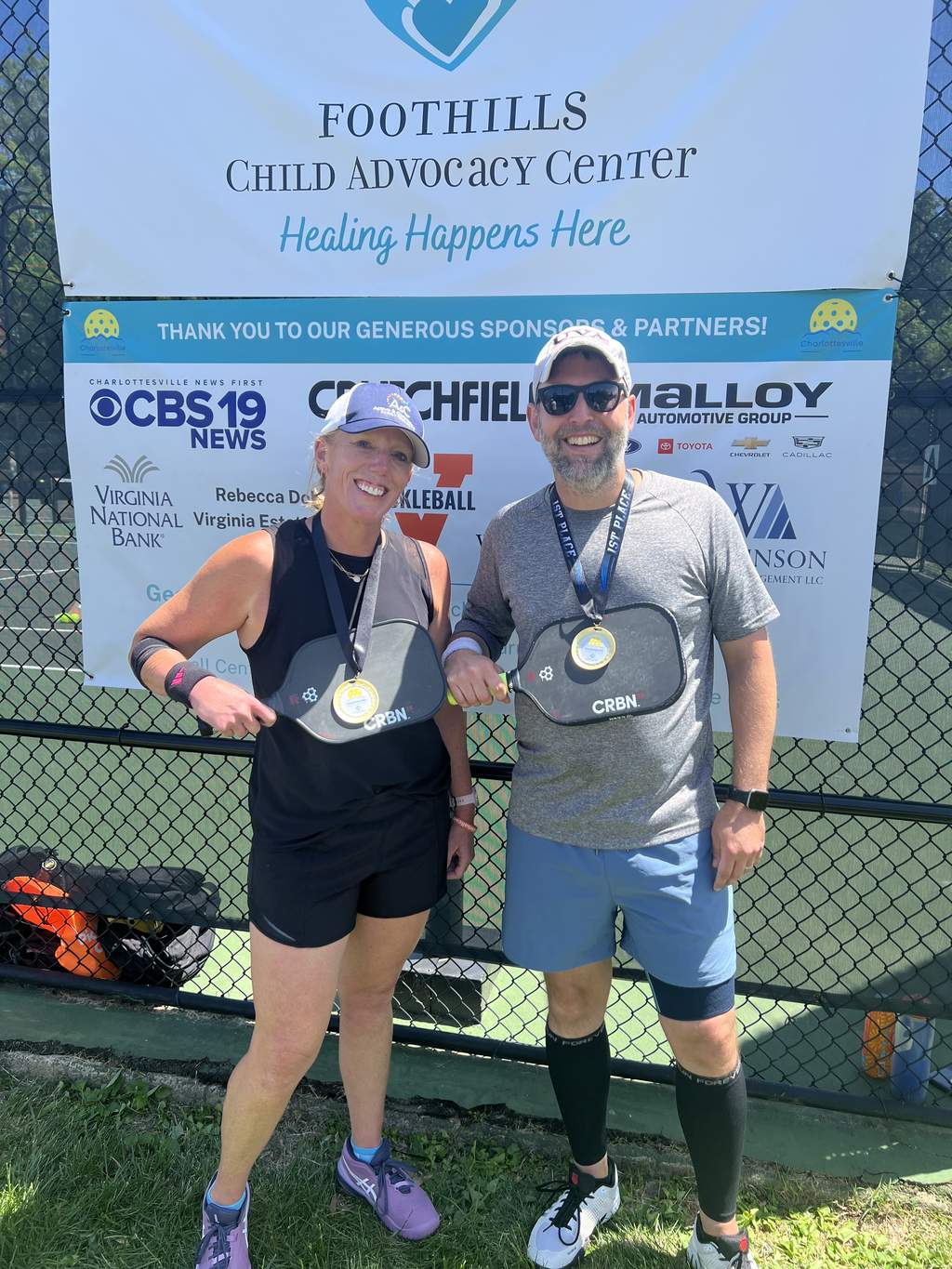 Amanda Sovik-Johnston and partner John Gaskins with first-place medals at the Foothills Child Advocacy Center pickleball tournament in Charlottesville, Virginia.